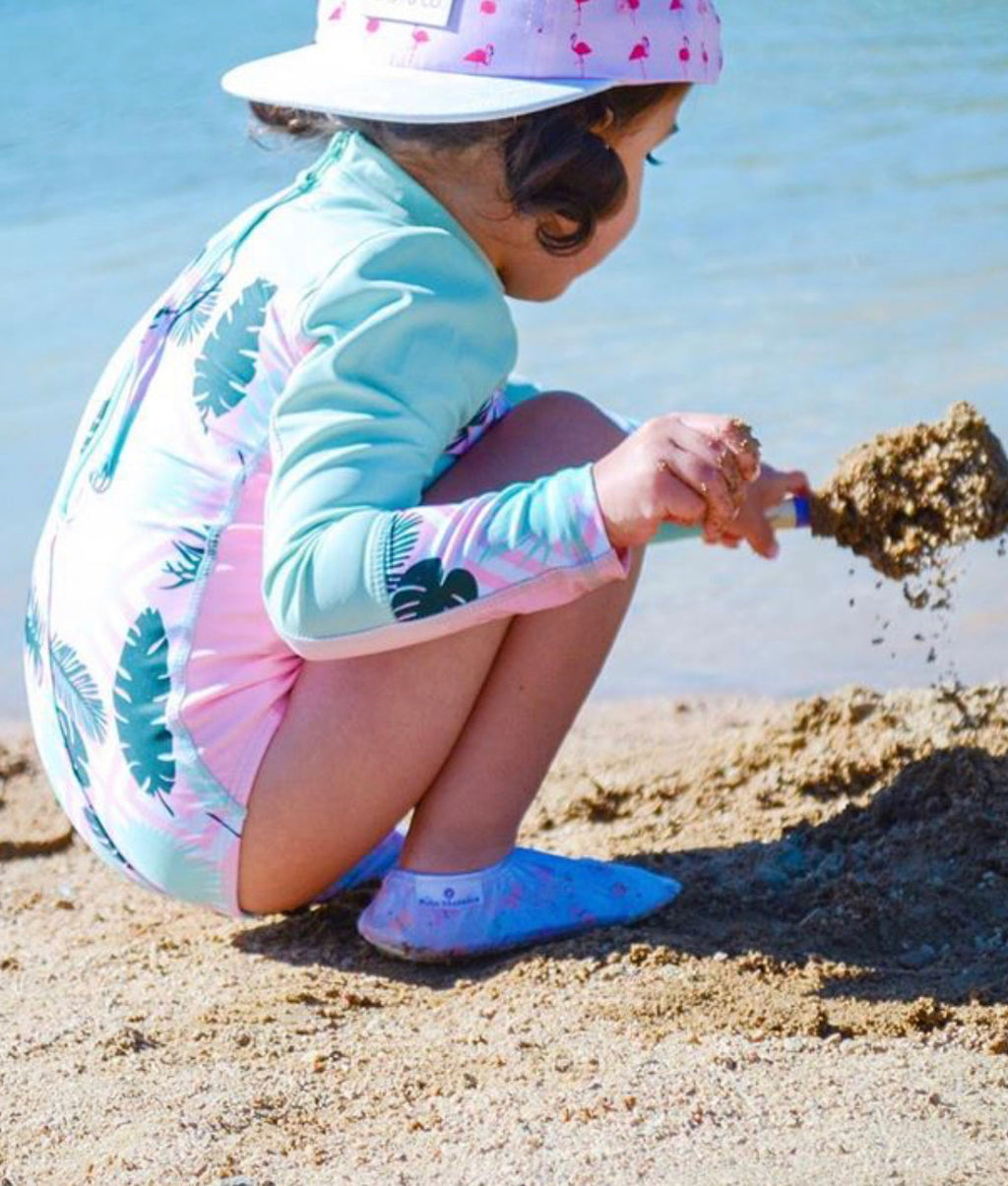 Chaussons d'eau motifs papillons portés par un enfant à la plage