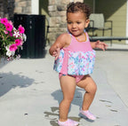 Chaussons d'eau motifs papillons portés par un enfant à la piscine