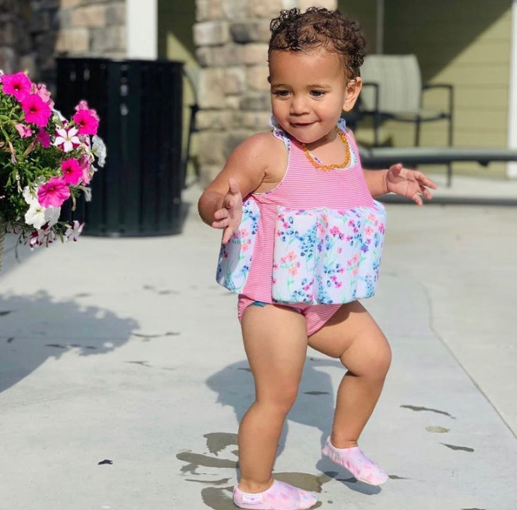 Chaussons d'eau motifs papillons portés par un enfant à la piscine