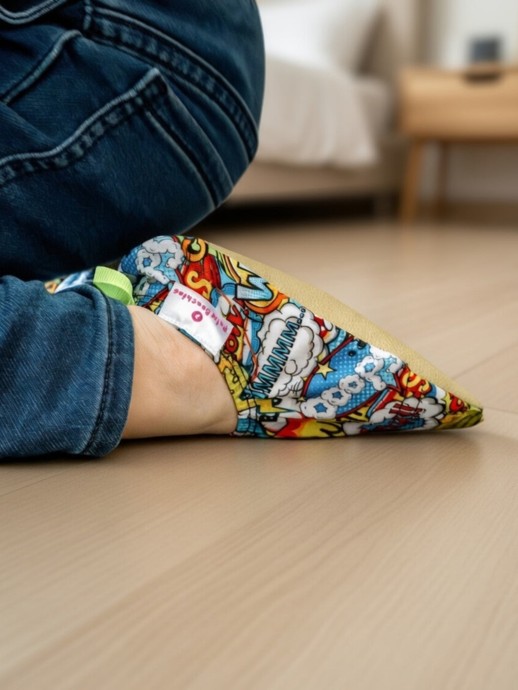 Chaussons d'eau motifs comics portés par un enfant en intérieur
