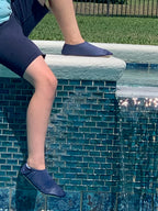 Chaussons d'eau navy portes par un enfant au bord de la piscine
