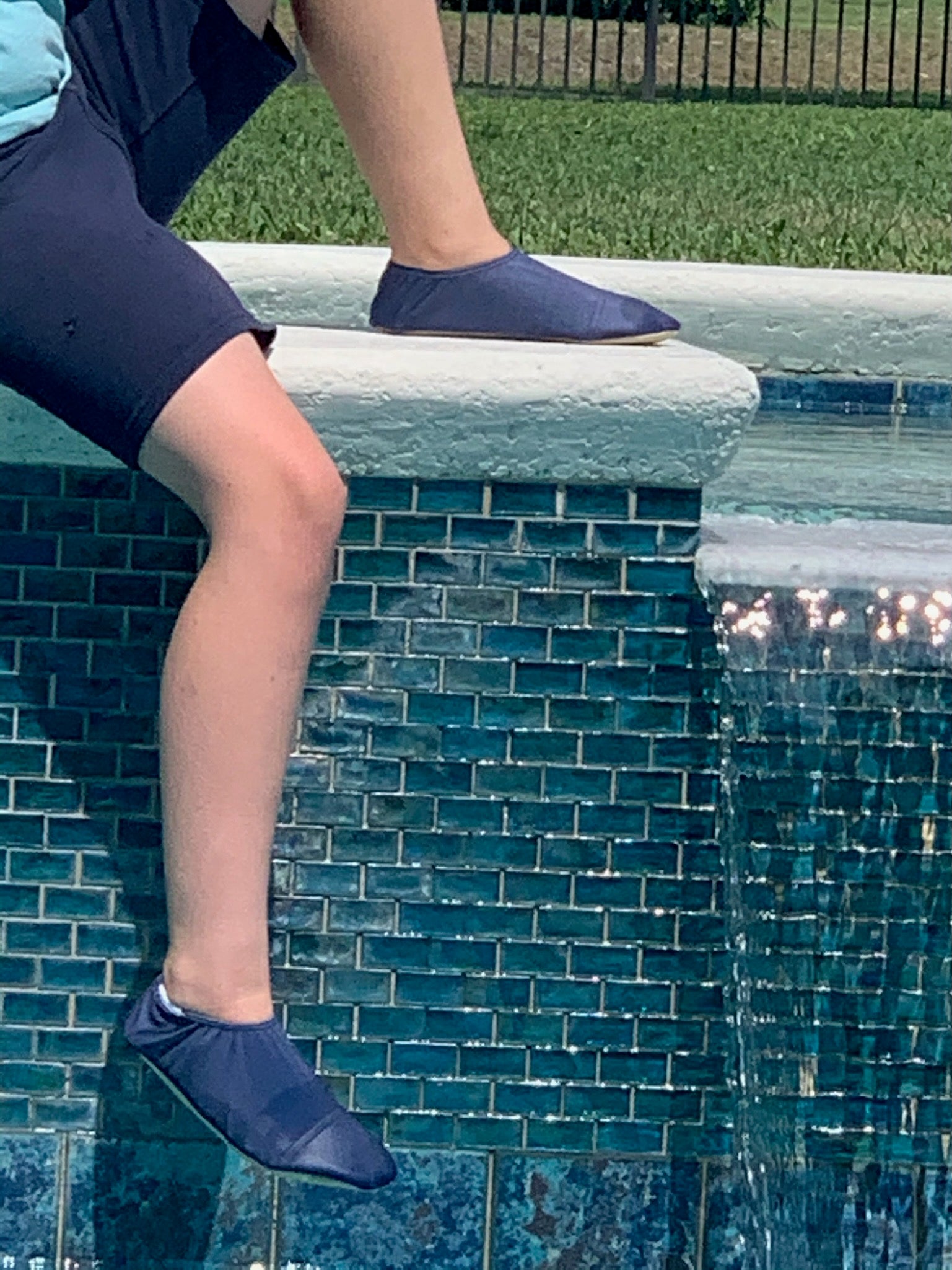 Chaussons d'eau navy portes par un enfant au bord de la piscine