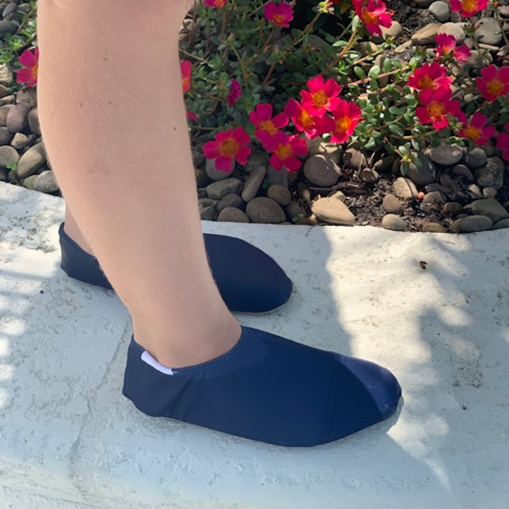 Chaussons d'eau navy portés par un enfant dans le jardin
