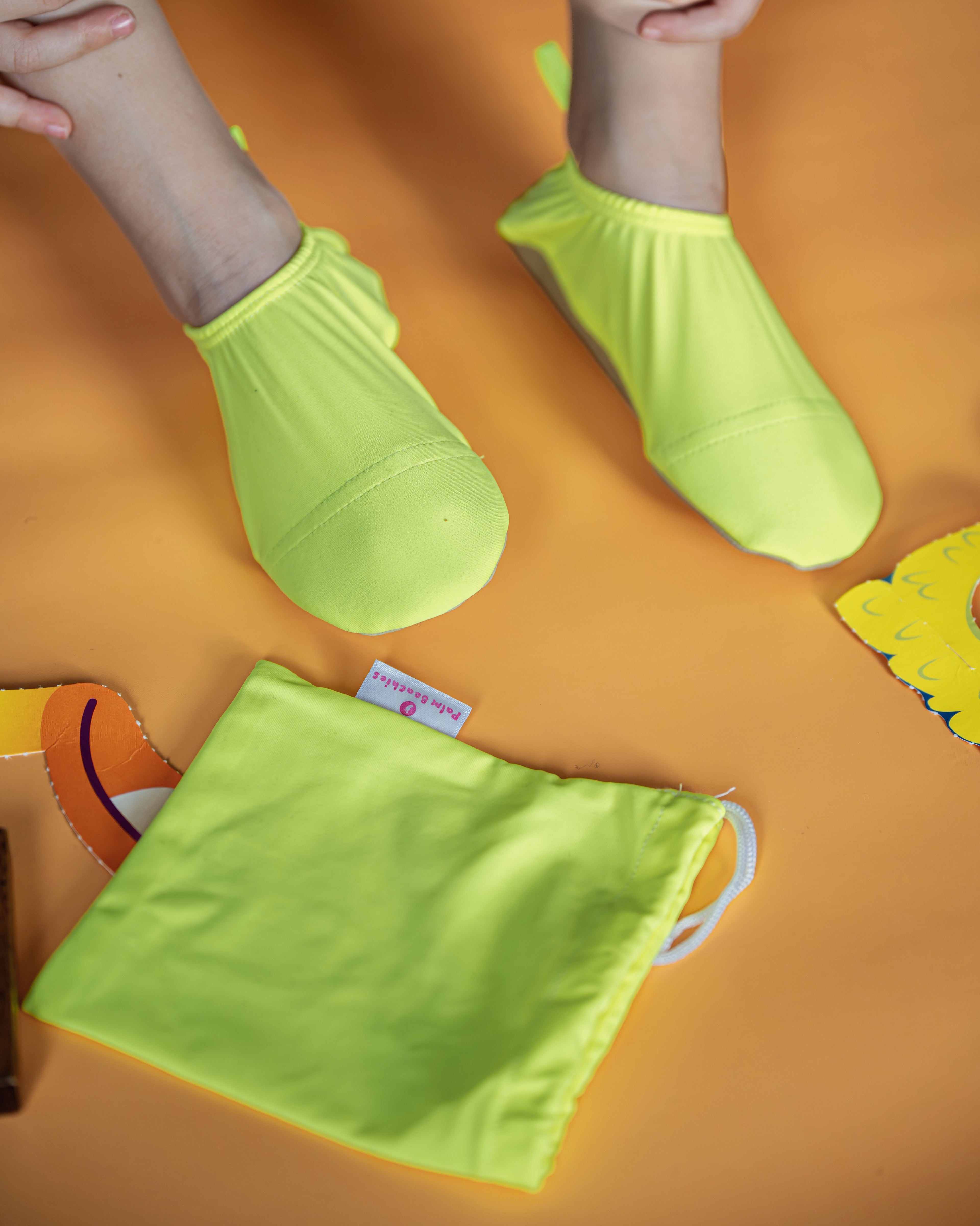 Chaussons d'eau jaune fluo portés par un enfant en intérieur
