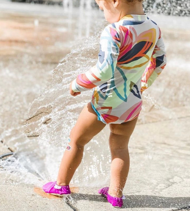 Chaussons d'eau violet portés dans l'eau par un enfant