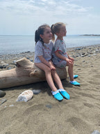Chaussons d'eau turquoises portés au bord de la plage