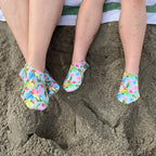 Chaussons d'eau motifs tropicaux portes par une maman et son enfant
